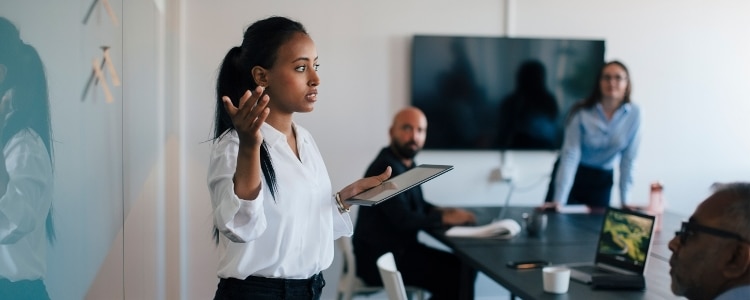 Individual delivering a presentation to others in a conference room.