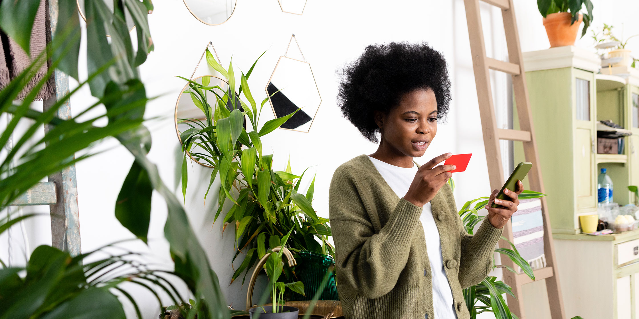 A person looks at their credit card and their phone to find out about processing fees.